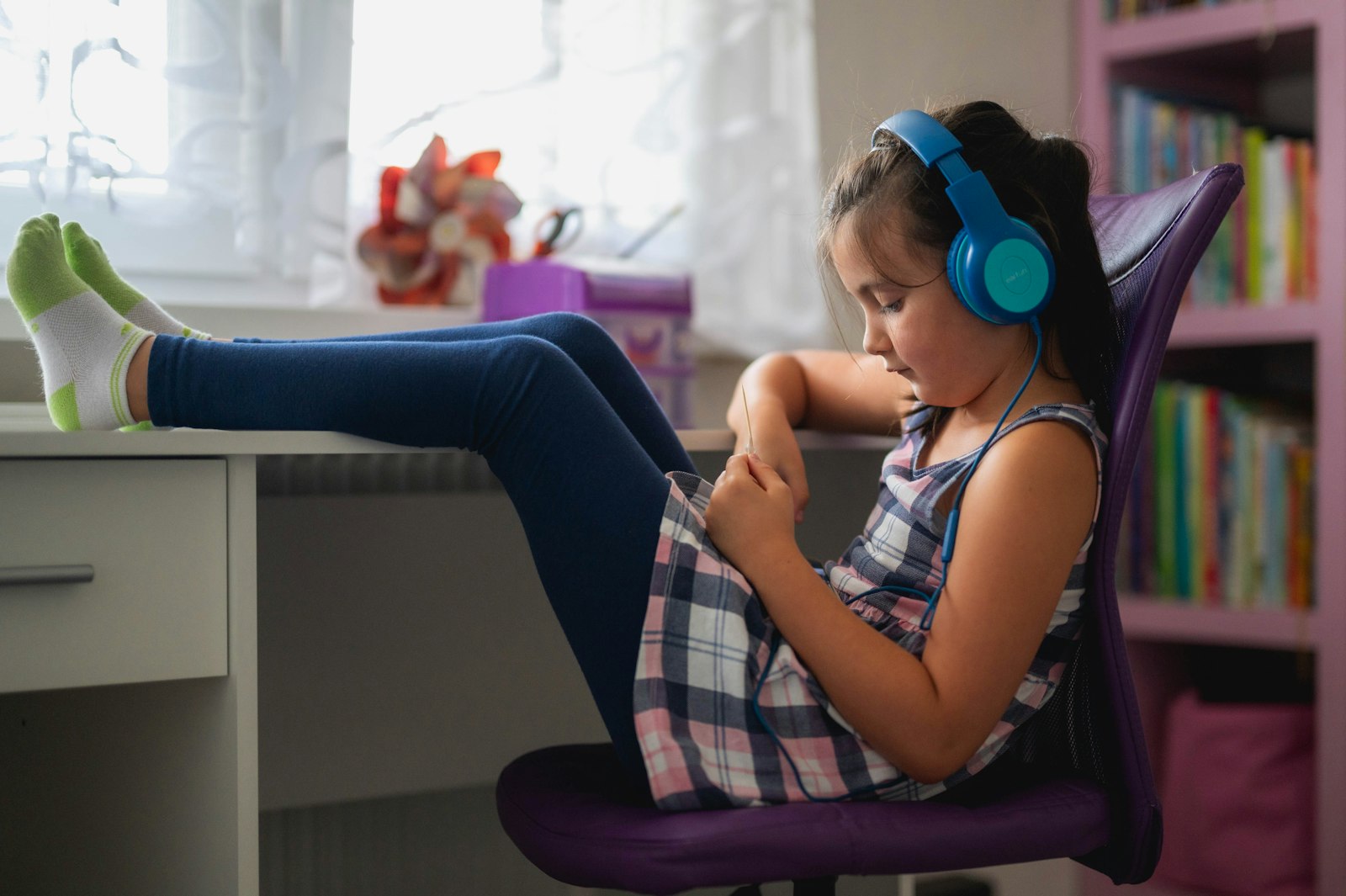Young girl listening calmly to an audio story, the kind a Yoto Player or Toniebox plays at bedtime