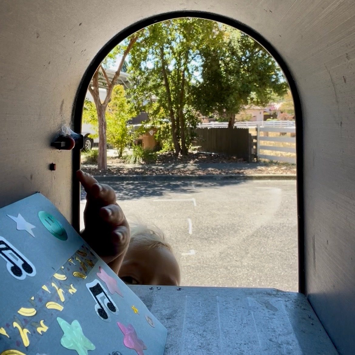 View from inside a mailbox as a child pulls out their Mailbox Melodies envelope