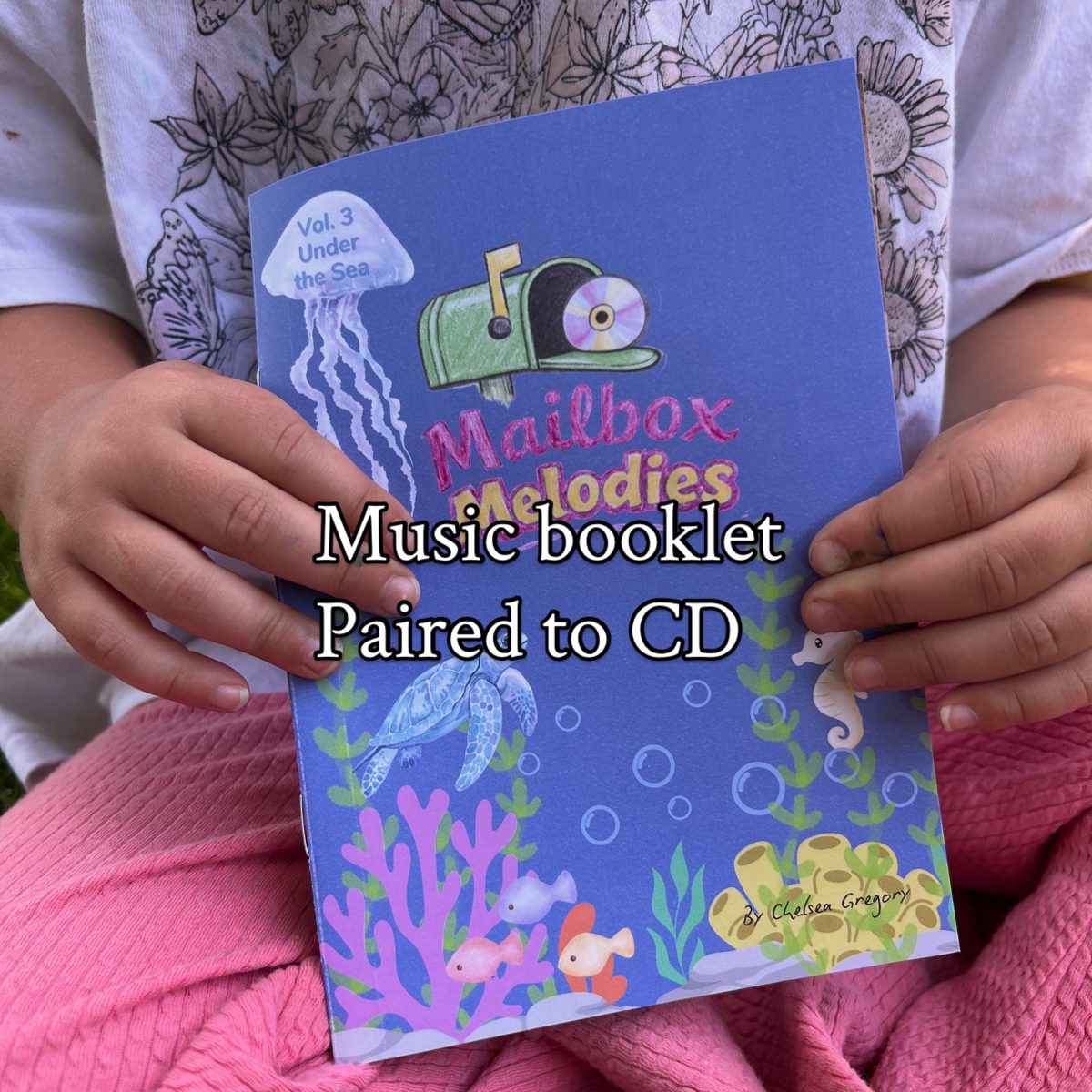 A child holding the music booklet made for that month