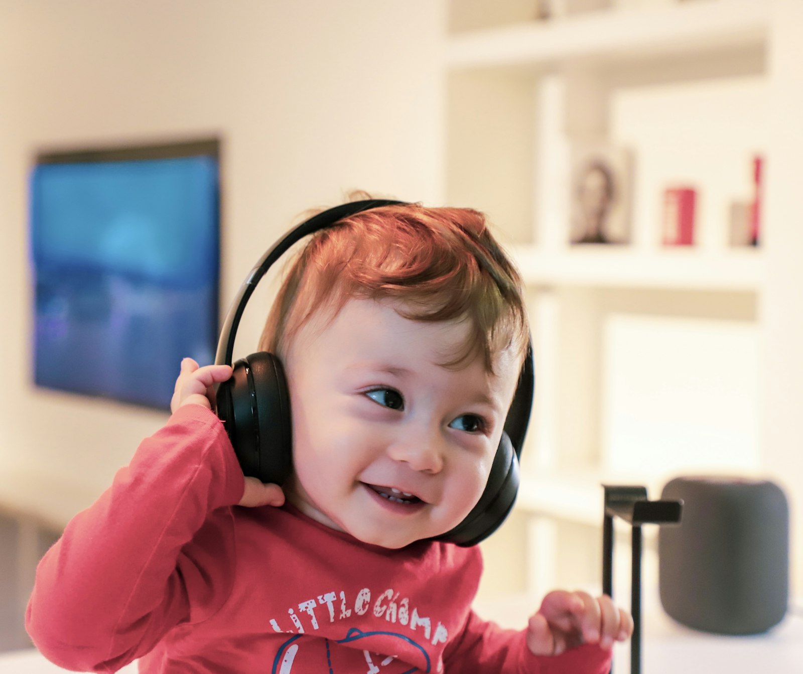 Toddler listening to an audio story on headphones, illustrating a Toniebox vs Yoto comparison for ages 0 to 6
