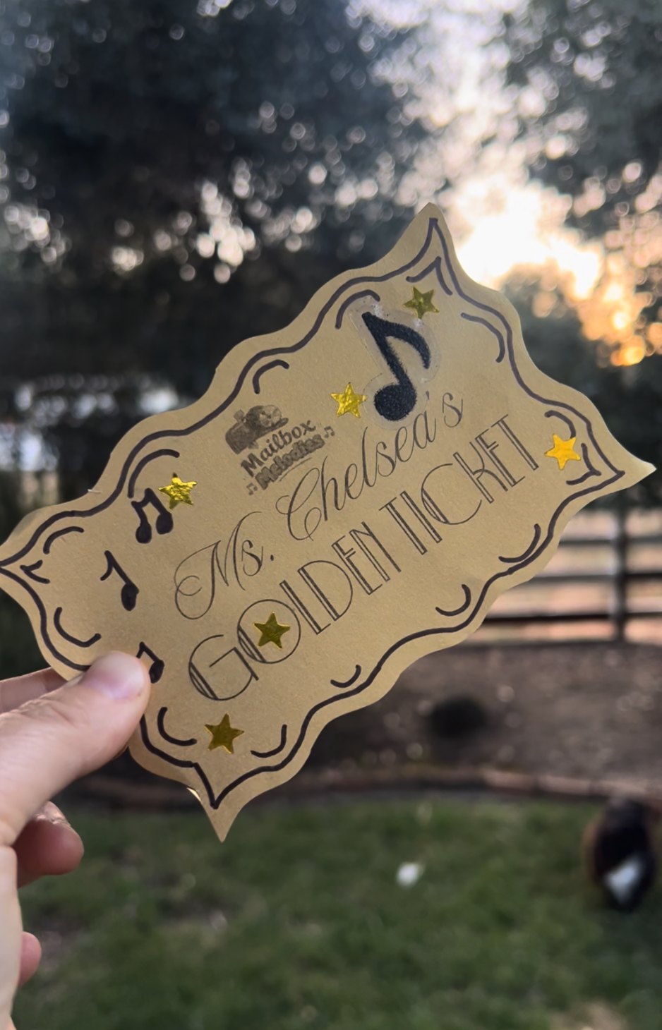 Ms. Chelsea's Golden Ticket — the monthly giveaway ticket held up at sunset