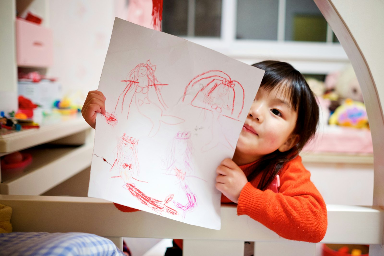 A child holding up a drawing she made while music played