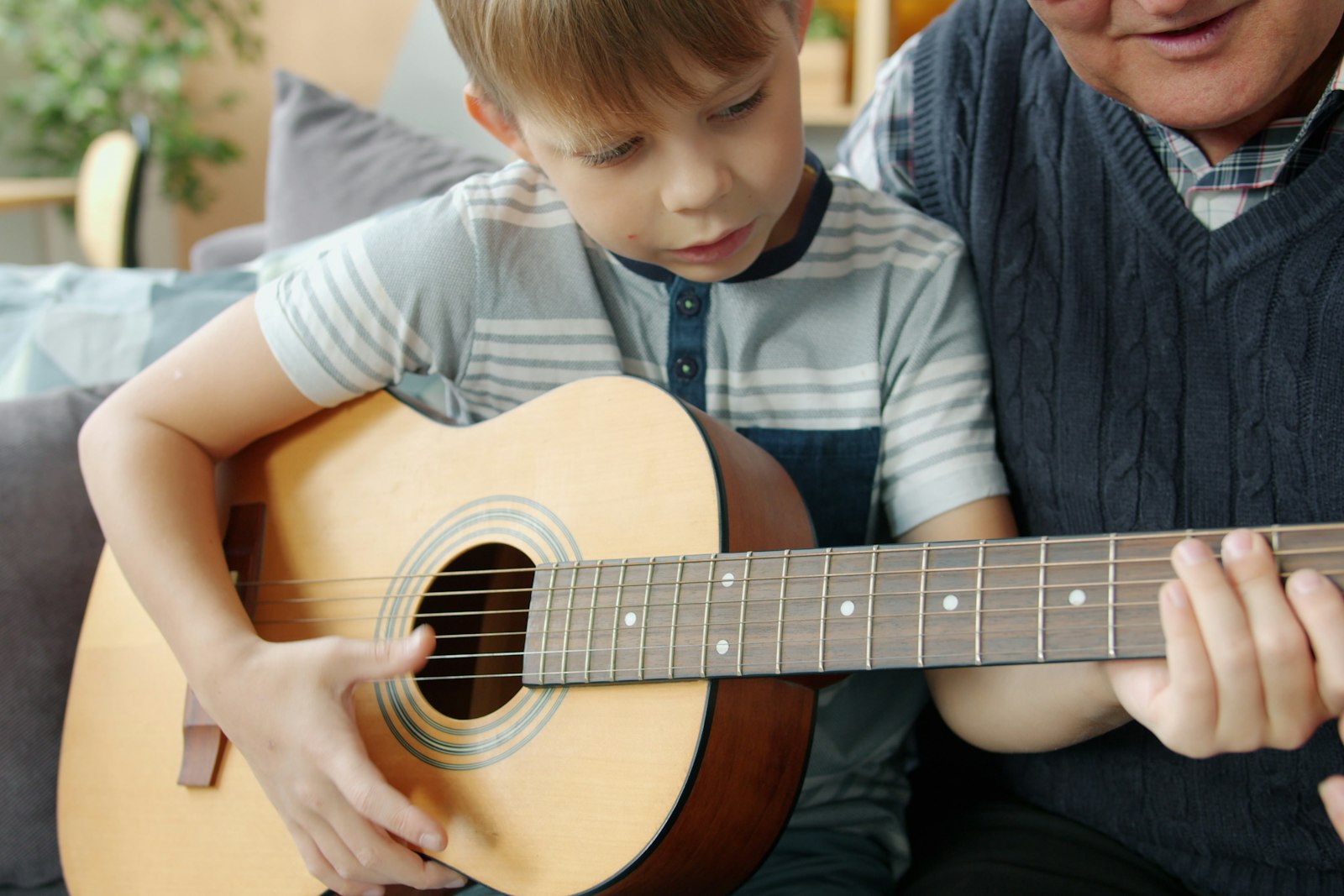 A six-year-old holding an acoustic guitar