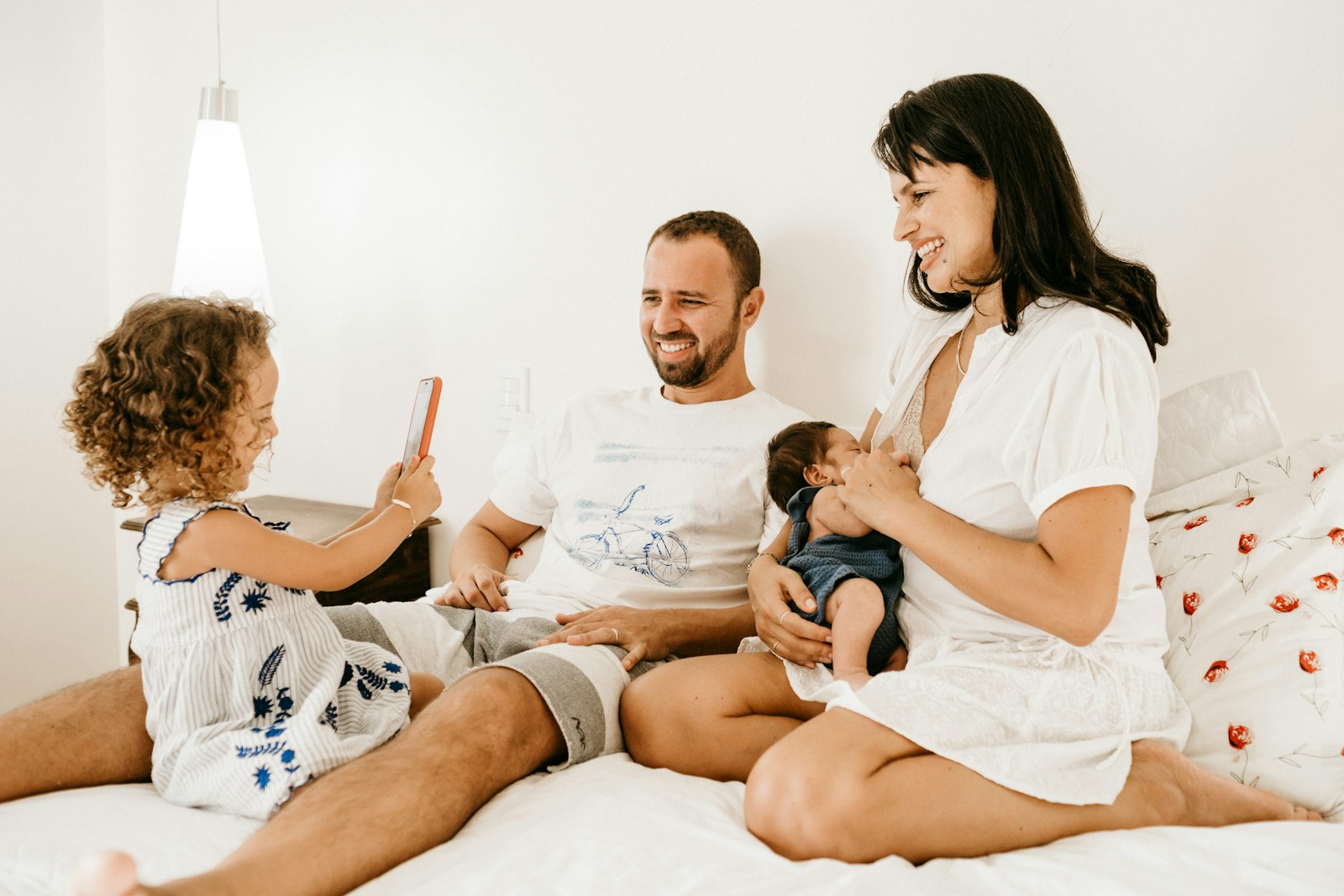 A family sitting together on a bed listening to music