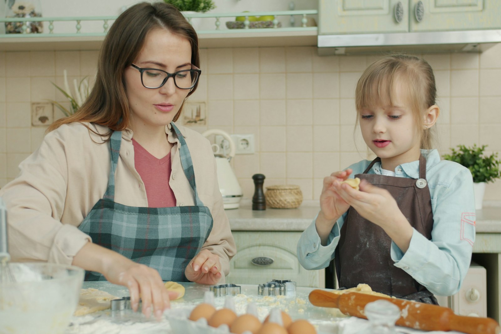 Parent and toddler baking cookies together at the kitchen counter, a screen-free activity for kids