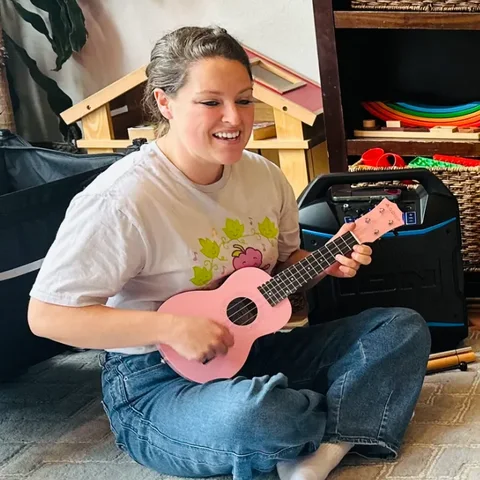Ms. Chelsea playing ukulele during a music class