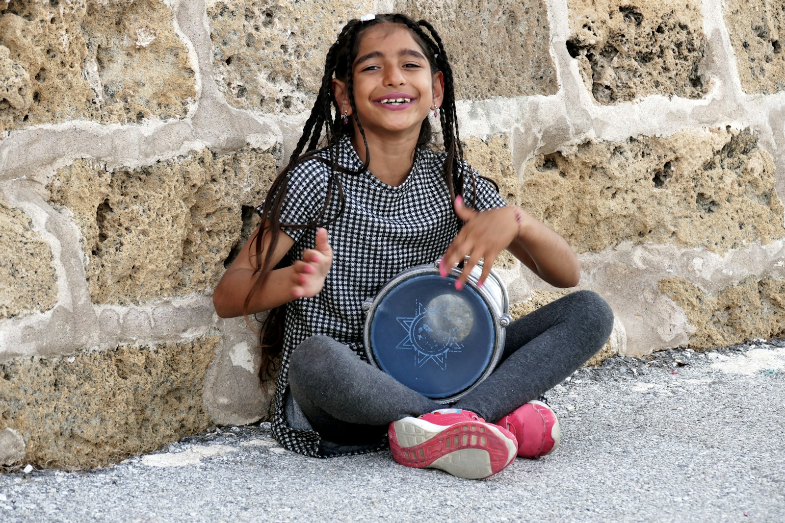 Child playing a hand drum in a simple at-home toddler music circle