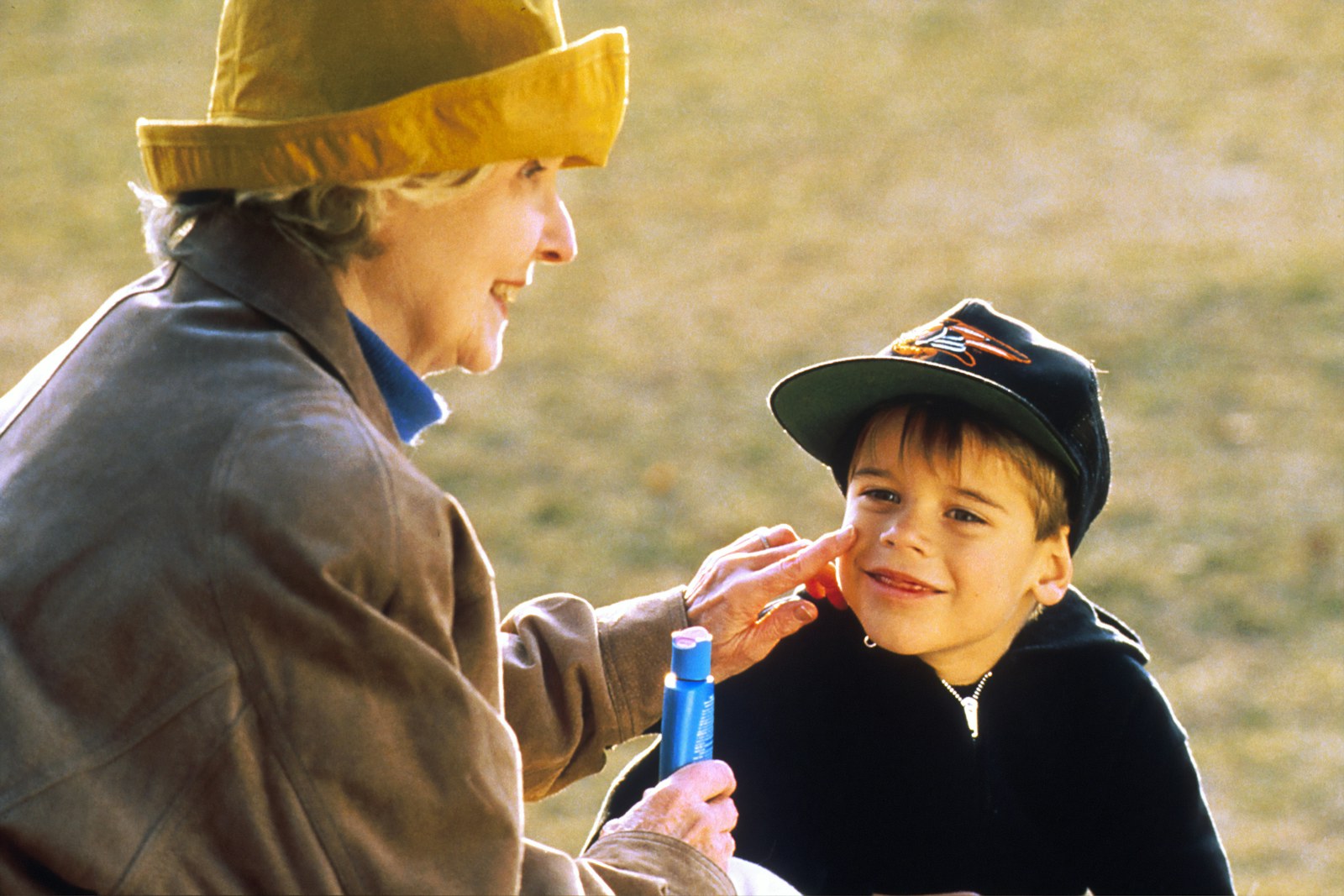 A grandmother and her grandson playing outdoors together during a visit